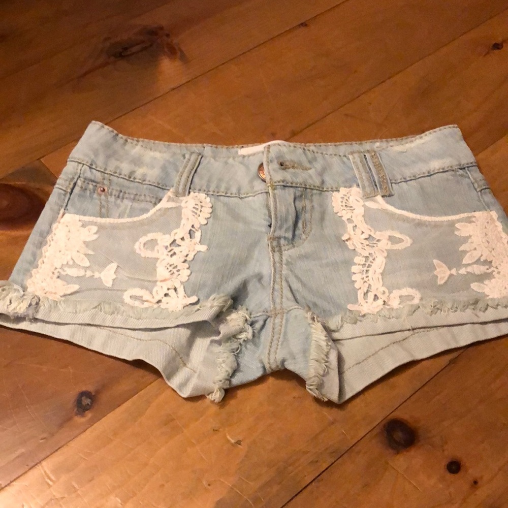 Adorable and sexy denim stretch cut offs with lace detail on front pockets. New.